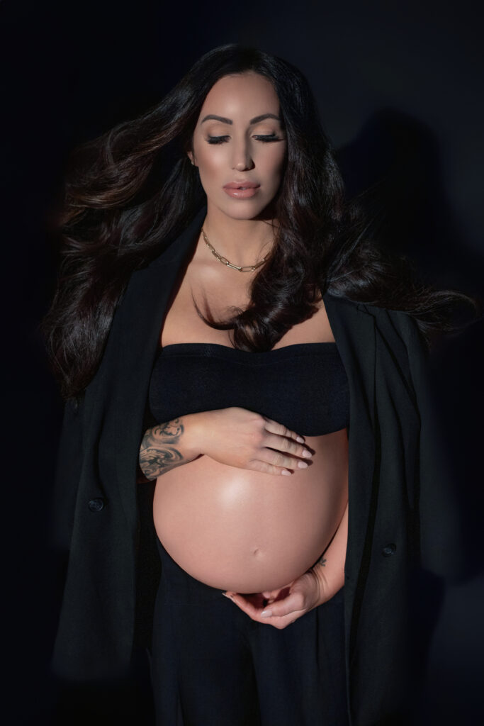 Editorial maternity portrait in Oklahoma City with chic black suit and dramatic lighting