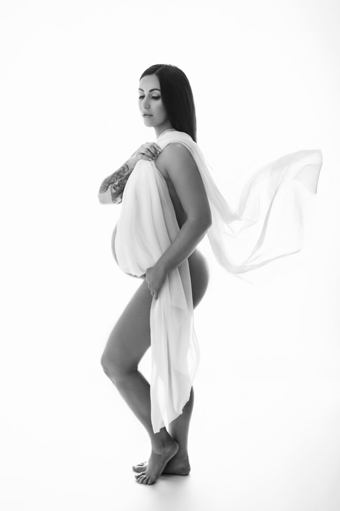 High-key editorial maternity photography in Oklahoma City with sheer white fabric draping