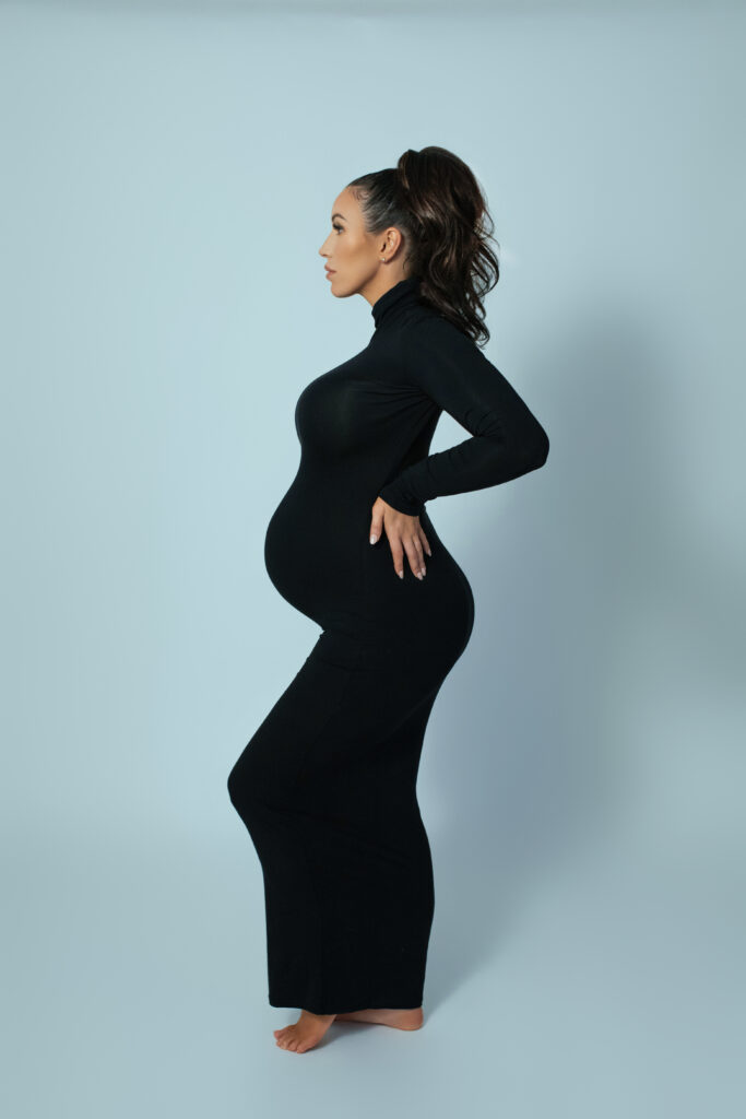 Fashion-forward maternity photography in Oklahoma City featuring black dress and high ponytail