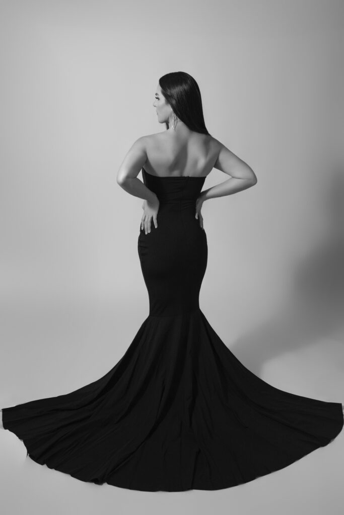 Black and white editorial portrait of woman in long dramatic dress in Oklahoma City studio